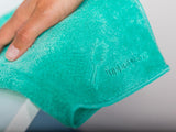 closeup of tupperware logo on a gree microfiber dust towel