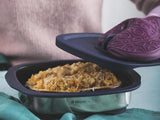 woman taking the cover off the tupperware micropro grill with food inside